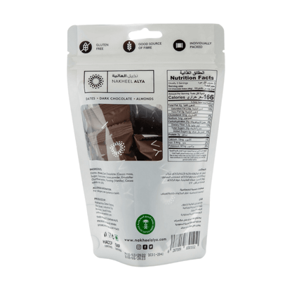 Achterkant verpakking van Pure Chocolade Dadels van Nakheel Alya, 100g. Individueel verpakte luxe snack met amandelen en voedingswaarden zichtbaar.